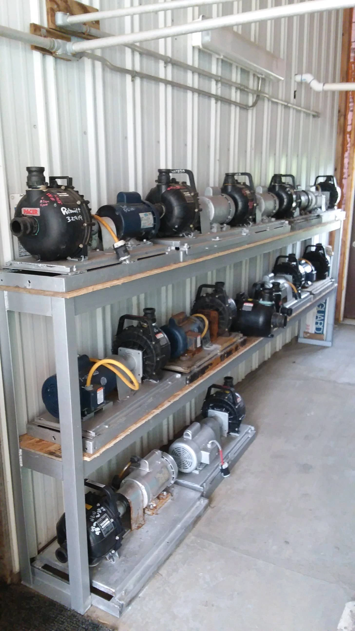 Various water and brine pumps are labeled and stored on steel shelves in the PennDOT Brine Shop.